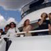 Happy passengers standing at the front of the second deck of charter yacht Miss Toronto